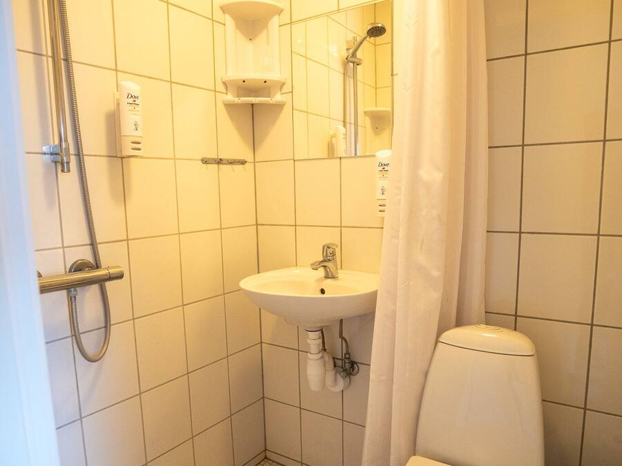 Ein Badezimmer mit Dusche, Waschbecken, Toilette und einer Duschvorhang.