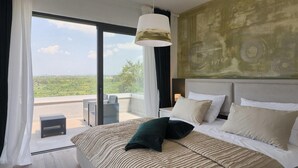 A bedroom with a large bed, a view of the outdoors, and a modern ceiling light. - Gorgeous home in Buje (Buje)