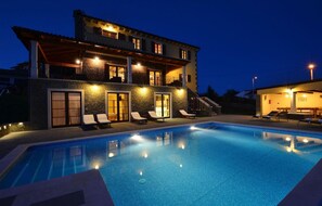 Relax by the pool surrounded by comfortable lounge chairs.