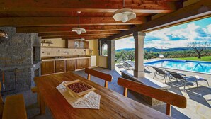 Interior em madeira com cozinha e área na piscina.