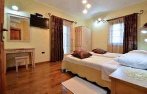 Cozy bedroom with a double bed, desk, wardrobe, and TV.