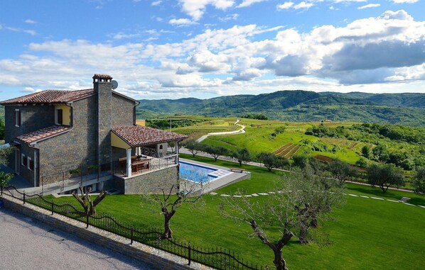 Enjoy an outdoor space with a swimming pool and scenic views of lush green fields and rolling hills.