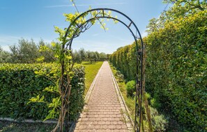 Stroll through the beautifully manicured garden, lined with neatly trimmed hedges and a variety of plants.