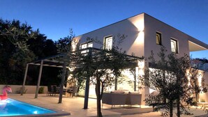 A modern house with a swimming pool, outdoor seating, and a covered patio area. - Gorgeous home in Pula with sauna (Pula)
