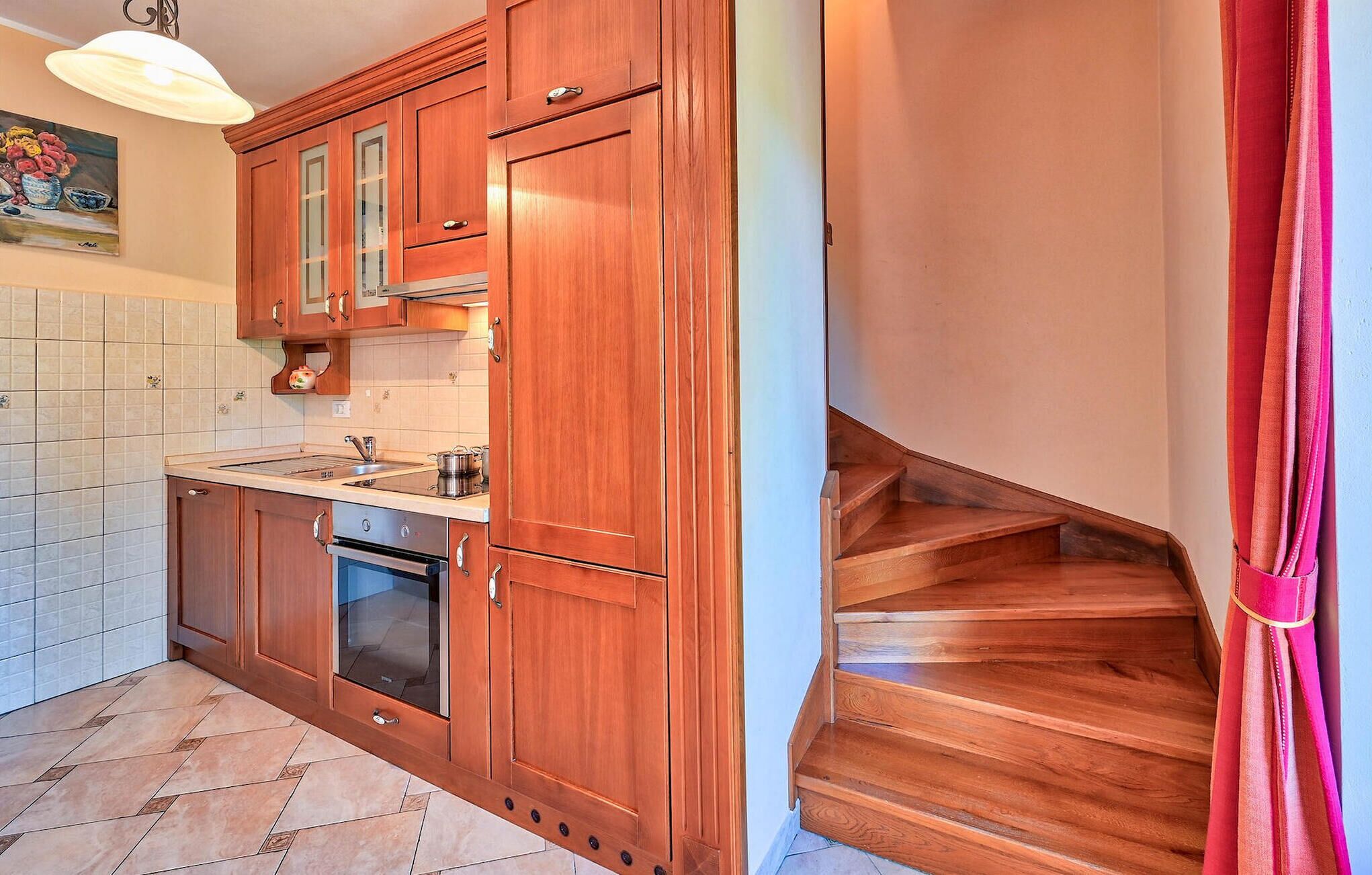 A kitchen with wooden cabinets, a stove, and a sink.