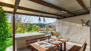 An outdoor dining area with a wooden table and benches, set against a backdrop of trees and a clear sky. - Gorgeous home in Boljun (Boljun)