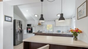 A modern kitchen with a central island, stainless steel appliances, pendant lighting, and a vase of flowers. - Gorgeous home in Boljun (Boljun)