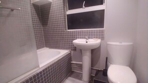 A bathroom with a bathtub, a sink, and a toilet.