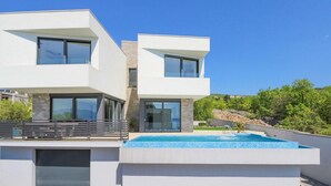 A modern two-story house with a swimming pool, large windows, and a balcony. - Stunning home in Kostrena with sauna (Kostrena)