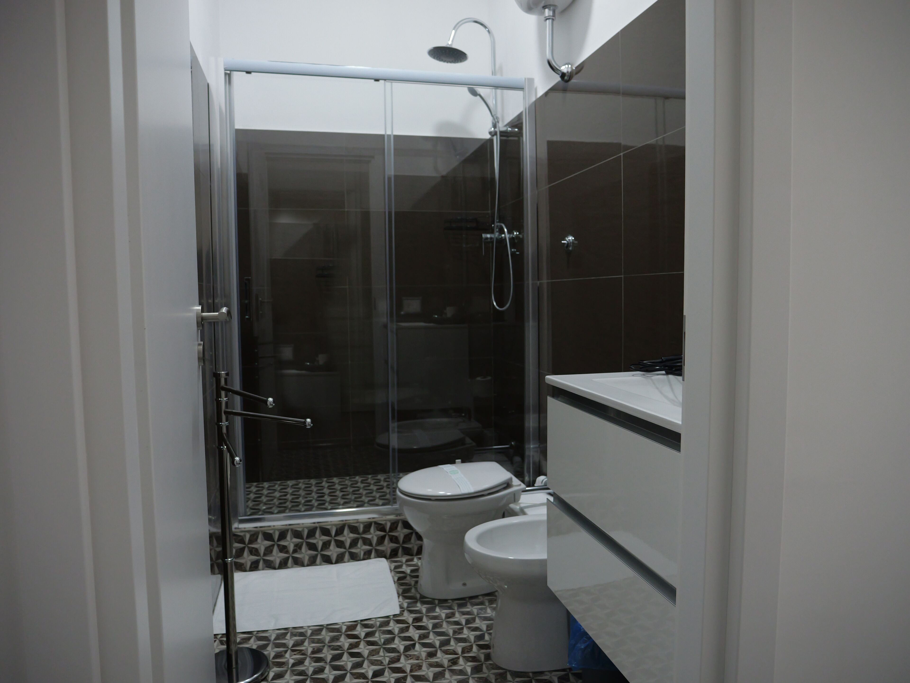 Ein kleines Badezimmer mit einer Duschkabine, einer Toilette und einem Waschbecken.