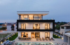 A modern two-story house with a swimming pool, outdoor seating, and a well-lit interior. - Beautiful home in Pula (Pula)