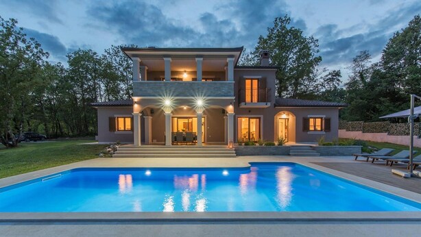 Une maison à deux étages avec une piscine à l’avant.