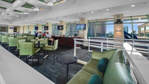 A modern indoor space with green seating, a counter, and large windows offering a city view. - Emerald Beach Resort 2235 (Panama City Beach)