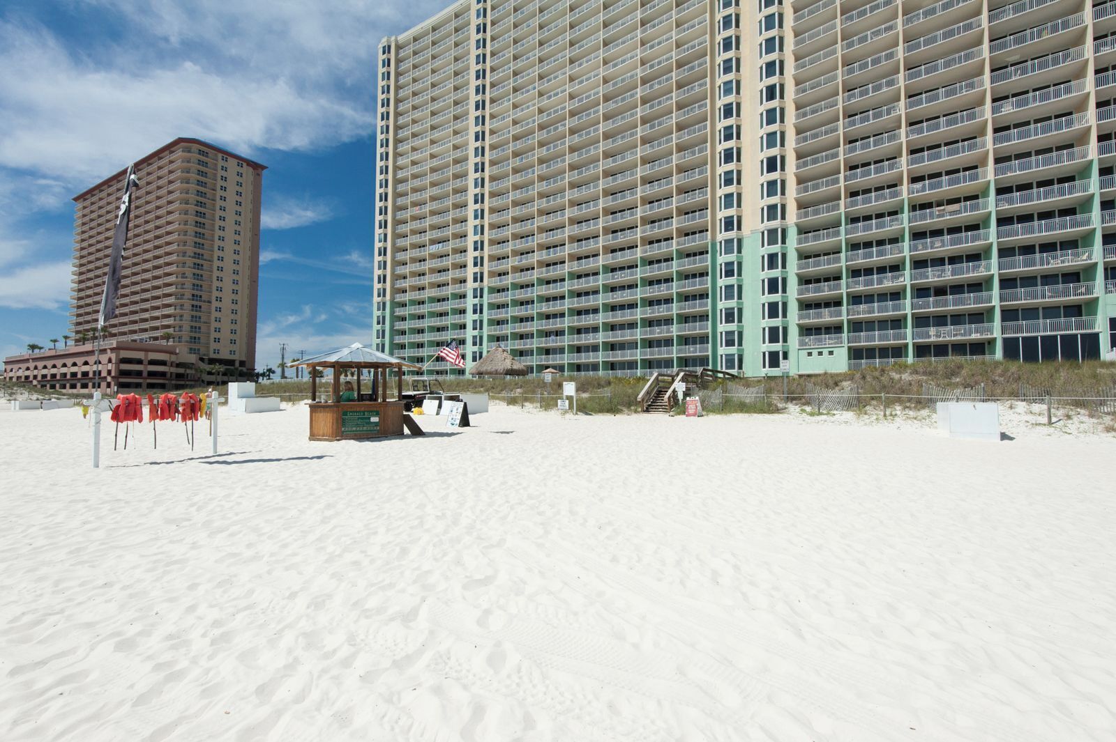 Een strand met een redderpost en een groot hotelgebouw op de achtergrond.