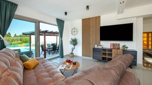 A modern living room with a large sofa, a coffee table, and a TV. - Stunning home in Sibenik (Sibenik)