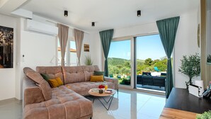 A modern living room with a sofa, coffee table, and a view of the outdoors. - Stunning home in Sibenik (Sibenik)