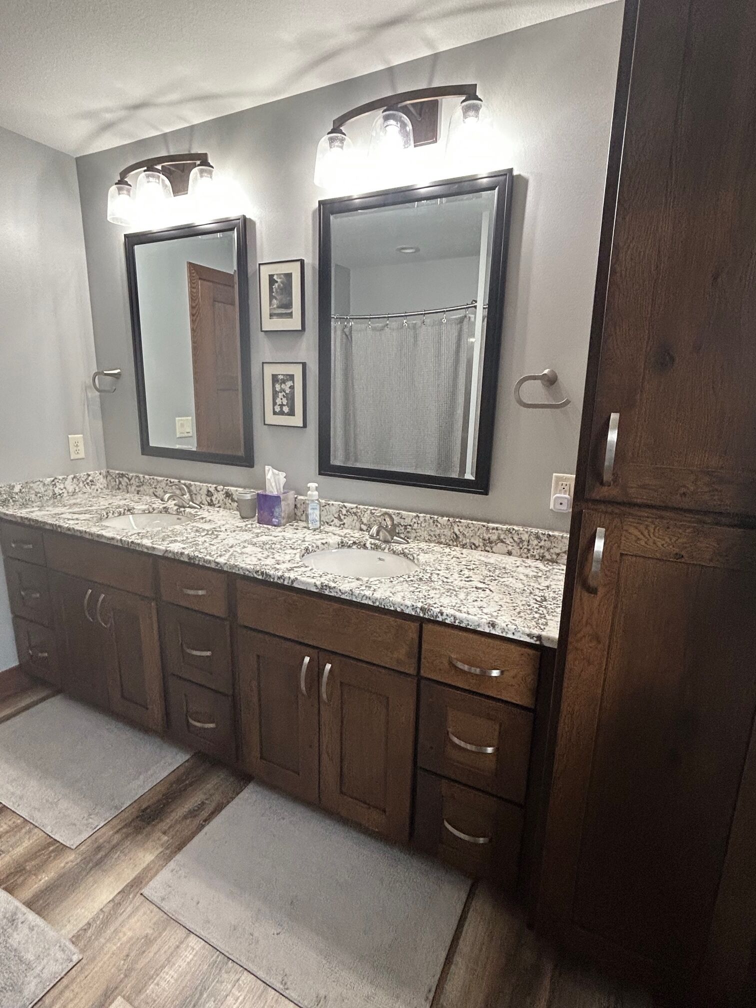 A bathroom with a double sink, vanity, and a large mirror.