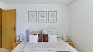A bedroom with a bed, pillows, a nightstand, and three framed cityscape pictures on the wall. - 1 bedroom lovely apartment in Zadar (Zadar)
