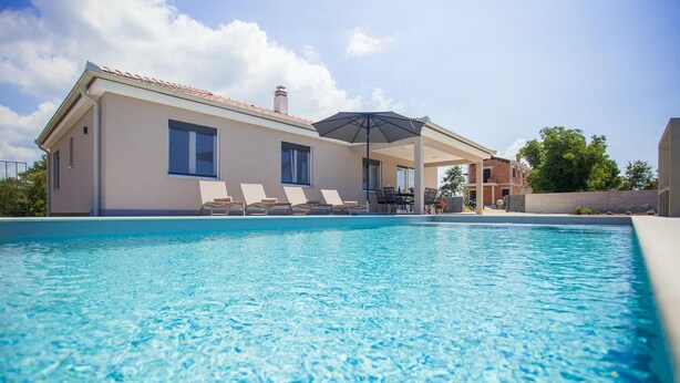 A swimming pool with lounge chairs and a covered patio area. - Gorgeous home in Kanfanar (Kanfanar)