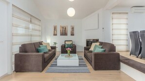 Un salon moderne avec deux canapés, une table basse et des œuvres d’art accrochées aux murs.