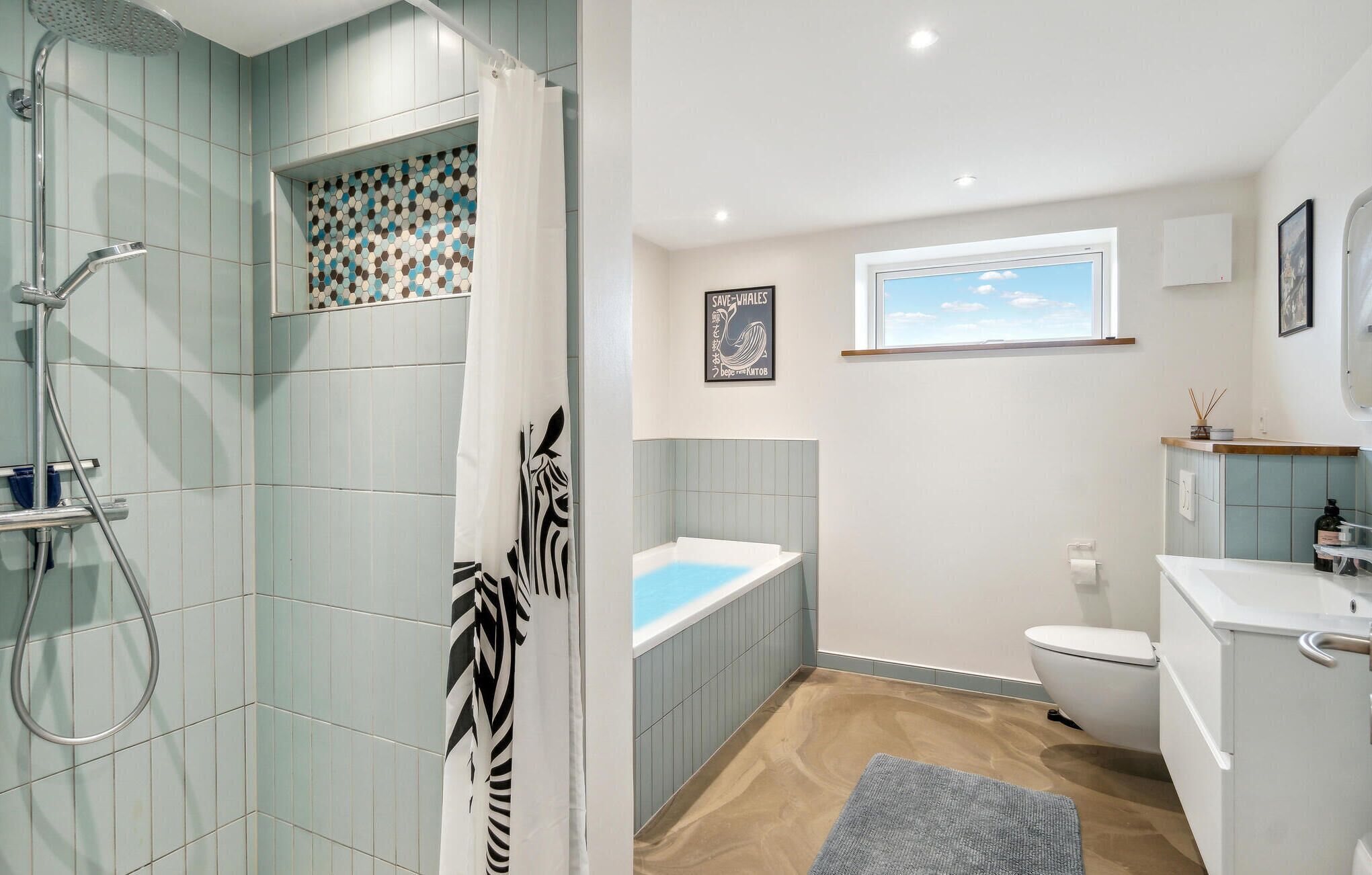 A modern bathroom with a shower, bathtub, toilet, and sink.