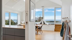 Una cocina moderna con una isla grande, un comedor con vistas y una zona de estar con vistas.