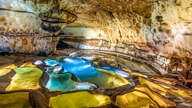 Une grotte dotée d’une piscine naturelle et de stalactites.