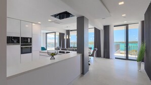 A modern kitchen with built-in appliances, a dining area with a view, and a balcony with a view. - Beautiful home in Medulin with sauna (Medulin)