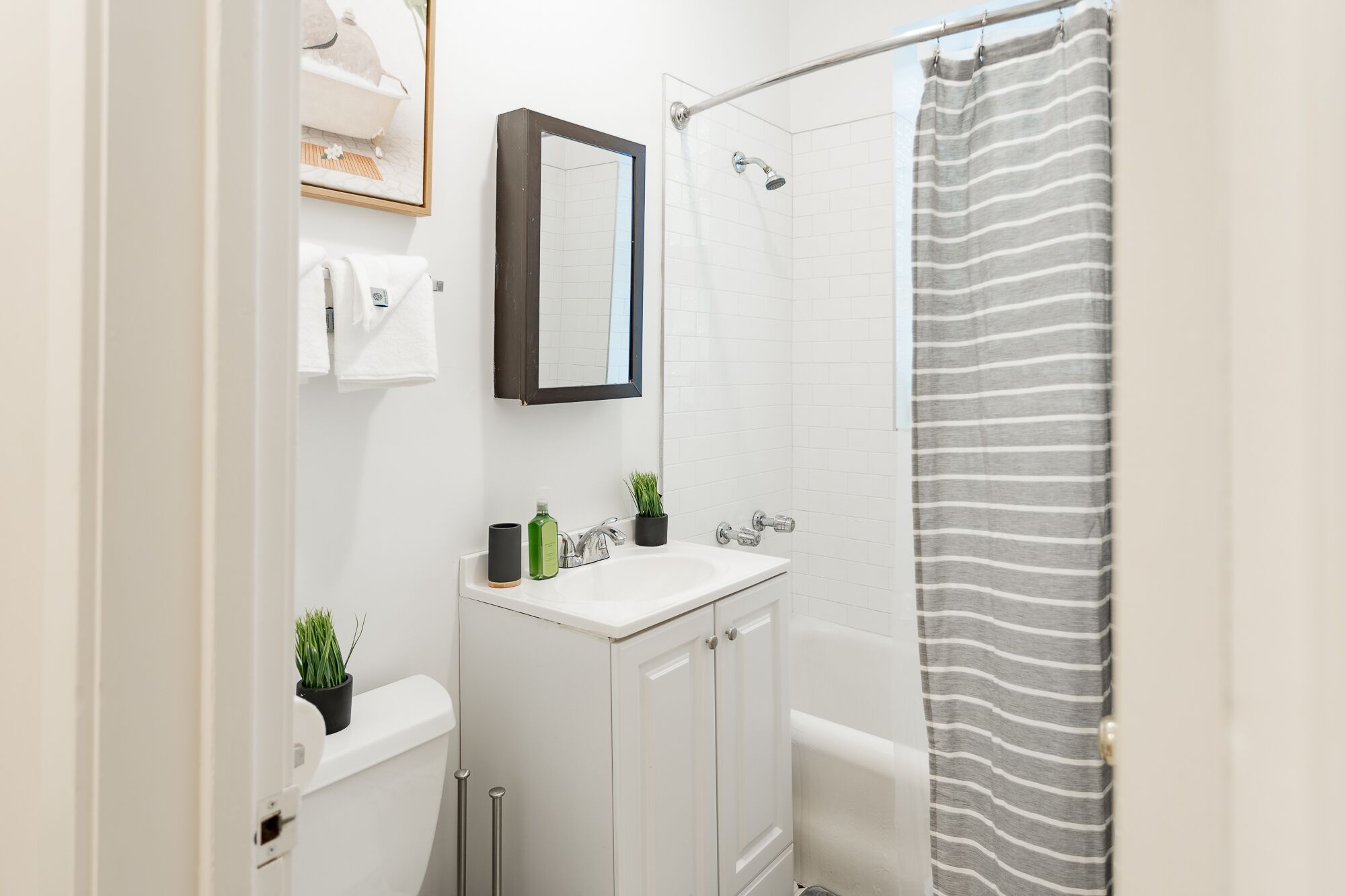 A bathroom with a shower, toilet, and sink.