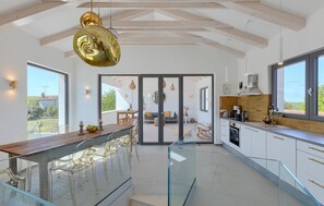 A modern kitchen with a glass bar, large windows, and a view of the outdoors. - Awesome home in Porec (Porec)