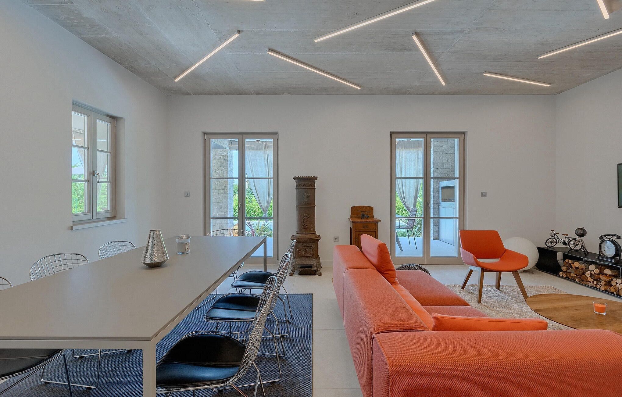 Ein moderner Konferenzraum mit einem langen Tisch, mehreren Stühlen, einer Couch und einem Kamin.