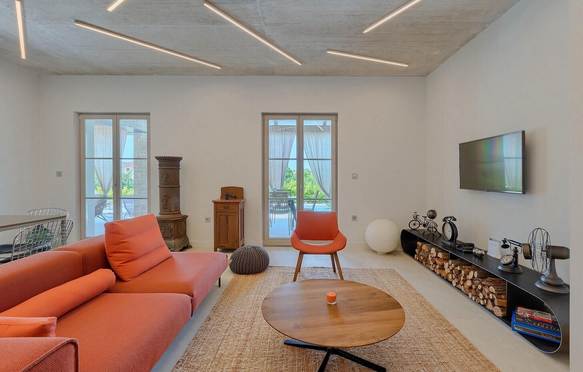 Una sala de estar moderna con un sofá, una mesa de centro, un televisor y una chimenea.