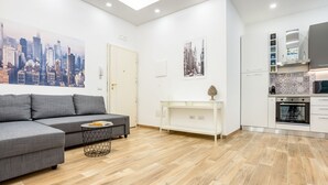 Ein modernes Wohnzimmer mit einem grauen Sofa, einem kleinen Couchtisch und einem Stadtbild an der Wand.