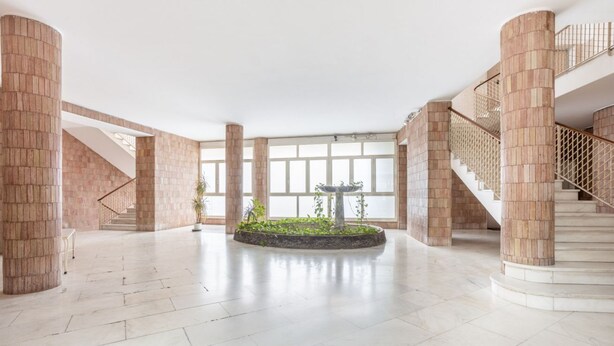 A spacious lobby with a central fountain, large columns, and a staircase. - GuestHost - Vomero Deluxe Paris with terrace (Napoli)
