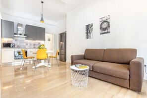 A modern kitchen with grey cabinets, a white countertop, and a yellow chair. - GuestHost - Vomero Deluxe Paris with terrace (Napoli)