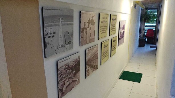 Ein Flur mit historischen Fotografien und Informationstafeln an der Wand.