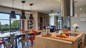 A modern kitchen with a central island, dining area, and large windows. - Awesome home in Svetvincenat (Svetvincenat)