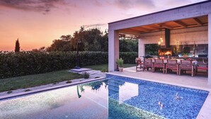 A modern outdoor kitchen with a pool and a dining area. - Awesome home in Svetvincenat (Svetvincenat)