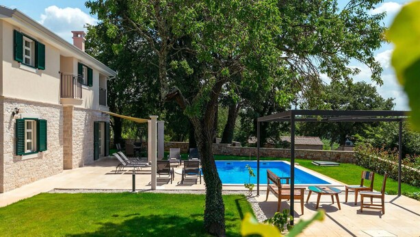 A two-story house with a swimming pool, outdoor seating, and a well-maintained lawn. - Gorgeous home in Porec (Porec)
