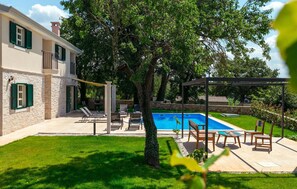 A two-story house with a swimming pool, outdoor seating, and a well-maintained lawn. - Gorgeous home in Porec (Porec)