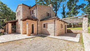 A stone house with a covered patio and a small garden area. - Amazing home in Tinjan (Tinjan)