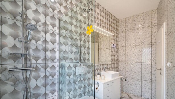 Ein Badezimmer mit Dusche, Toilette und Waschbecken.