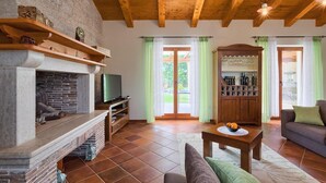 Ein Wohnzimmer mit Kamin, Fernseher und einer Weinauslage.