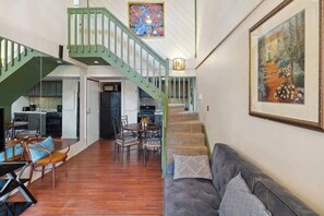 A spacious interior with a staircase, dining area, and a sofa. - Schuss Mountain Ski/Golf Condo (Mancelona)