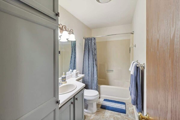 A bathroom with a sink, toilet, shower, and a towel rack. - Schuss Mountain Ski/Golf Condo (Mancelona)