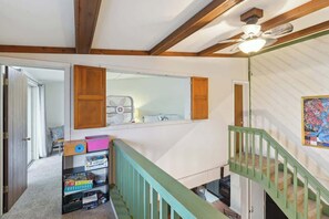A staircase with a green railing, a wooden ceiling, and a fan. - Schuss Mountain Ski/Golf Condo (Mancelona)