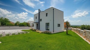 A modern two-story building with a flat roof, a well-maintained lawn, and a stone wall. - Awesome home in Tar-Vabriga (Tar-Vabriga)