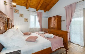 A bedroom with a wooden bed, a nightstand, a wardrobe, and a window with curtains. - Nice home in Visnjan with private swimming pool, can be inside or outside (Visnjan)