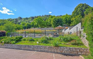 Surrounded by lush greenery and a stone wall, this tranquil outdoor space offers a peaceful retreat.