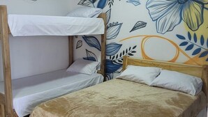 A bunk bed room with a floral mural on the wall, a white air conditioning unit, and a tiled floor. - Ecohotel La Reserva (Piojó)